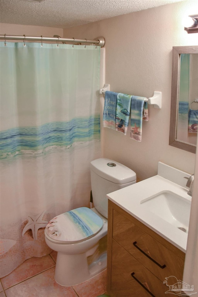 bathroom with vanity, a textured ceiling, tile patterned floors, and toilet