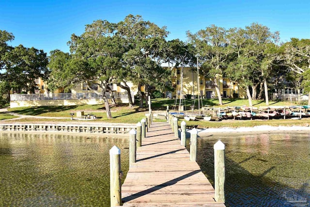 dock area featuring a water view and a yard