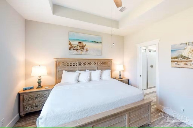 bedroom featuring baseboards, wood finished floors, and visible vents