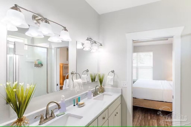 bathroom featuring connected bathroom, an enclosed shower, a sink, and double vanity
