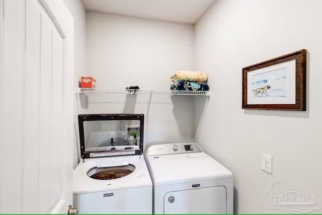 clothes washing area featuring washing machine and clothes dryer and laundry area