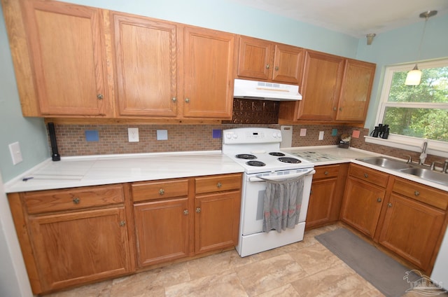 2153 Bergren Rd, Gulf Breeze, FL 32563 - kitchen with electric range, under cabinet range hood, decorative backsplash, brown cabinets, and light countertops
