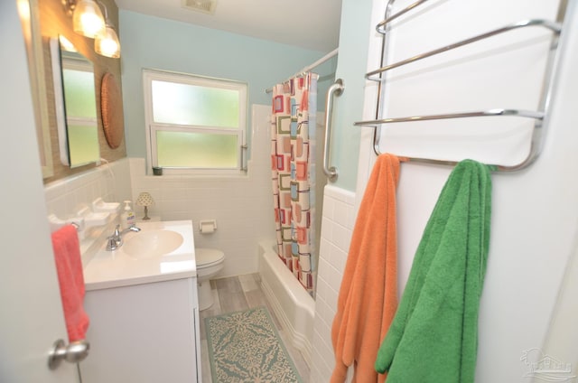 2153 Bergren Rd, Gulf Breeze, FL 32563 - bathroom featuring vanity, tile walls, shower / bath combo, and a wainscoted wall
