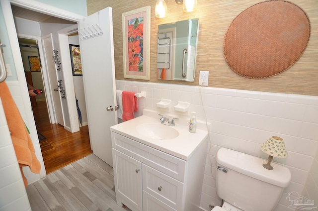 2153 Bergren Rd, Gulf Breeze, FL 32563 - half bathroom featuring tile walls, vanity, wood finished floors, and wainscoting