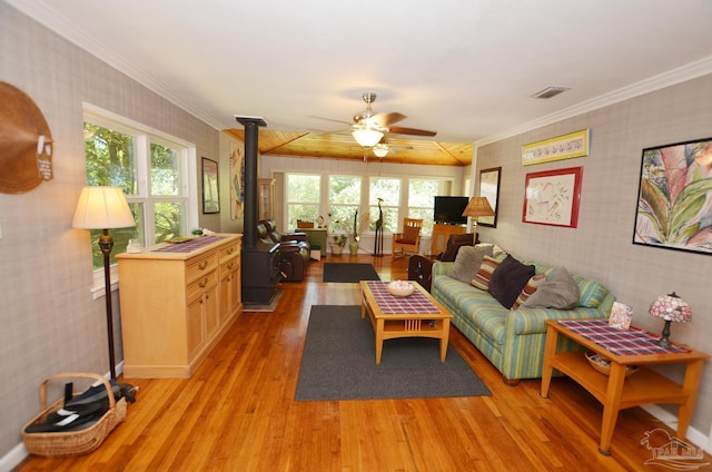 2153 Bergren Rd, Gulf Breeze, FL 32563 - living area with wallpapered walls, ceiling fan, light wood-style floors, a wood stove, and crown molding