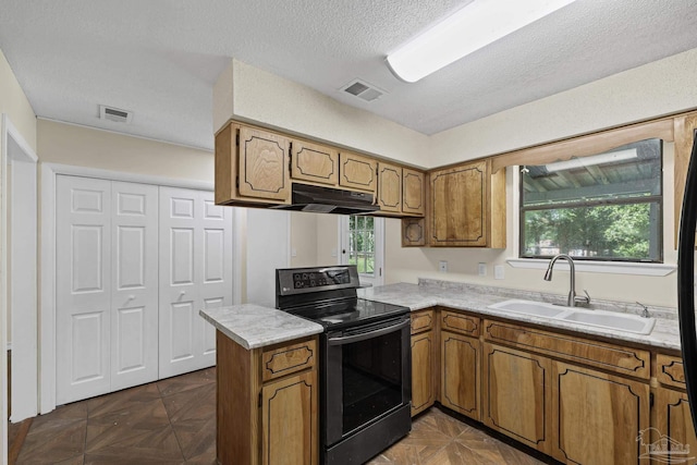 6136 Beasley Rd, Crestview, FL 32536 - kitchen featuring black electric range, under cabinet range hood, brown cabinetry, light countertops, and a textured ceiling