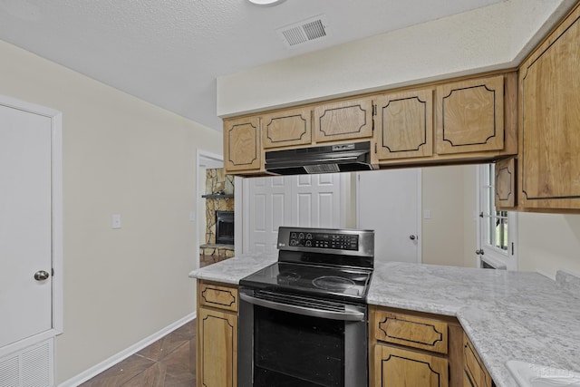 6136 Beasley Rd, Crestview, FL 32536 - kitchen with under cabinet range hood, black / electric stove, light countertops, and brown cabinets