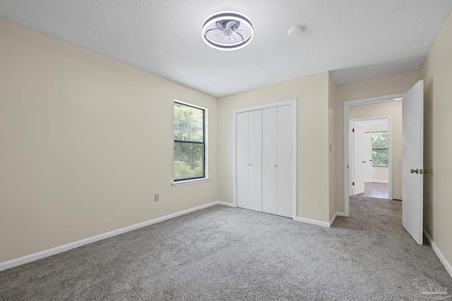 6136 Beasley Rd, Crestview, FL 32536 - unfurnished bedroom with multiple windows, carpet, a closet, and a textured ceiling