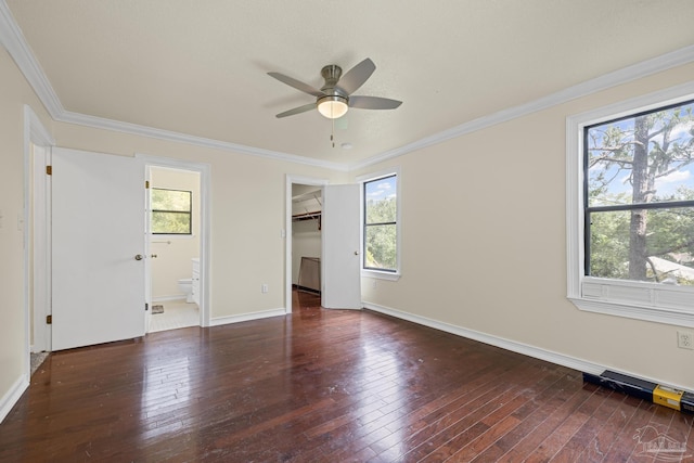 6136 Beasley Rd, Crestview, FL 32536 - unfurnished bedroom featuring multiple windows, hardwood / wood-style floors, ornamental molding, and a walk in closet