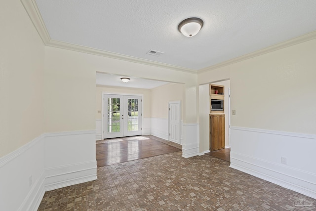 6136 Beasley Rd, Crestview, FL 32536 - unfurnished room featuring a wainscoted wall, french doors, ornamental molding, and a textured ceiling