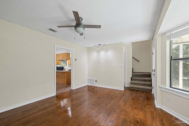 6136 Beasley Rd, Crestview, FL 32536 - spare room with hardwood / wood-style flooring, stairs, a ceiling fan, and a textured ceiling