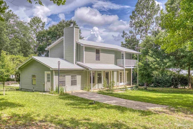 6136 Beasley Rd, Crestview, FL 32536 - rear view of property featuring covered porch, a yard, a chimney, and a metal roof