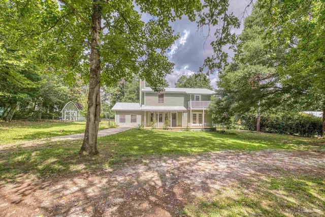 6136 Beasley Rd, Crestview, FL 32536 - view of front of property with a balcony, a front yard, a chimney, and a storage shed