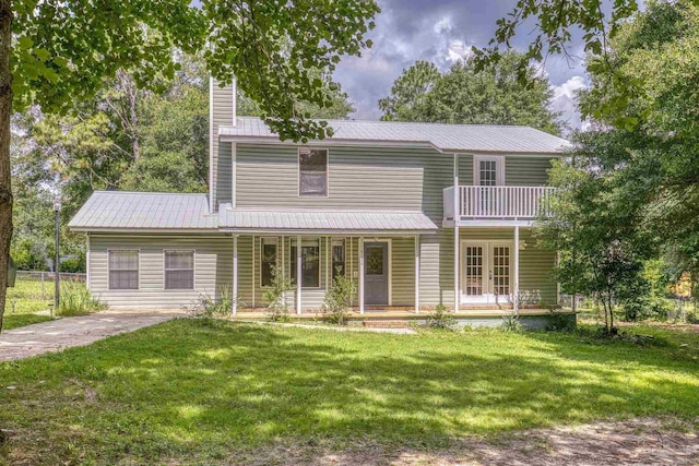 6136 Beasley Rd, Crestview, FL 32536 - view of front of house with french doors, a front lawn, a metal roof, a balcony, and covered porch