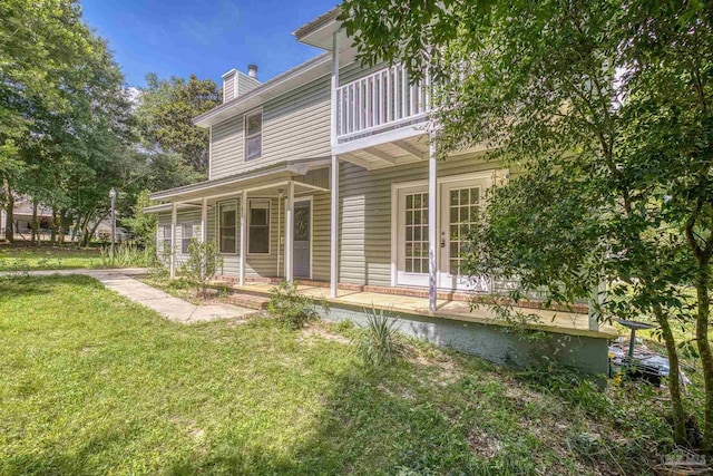 6136 Beasley Rd, Crestview, FL 32536 - rear view of property featuring a chimney, a lawn, a balcony, and covered porch