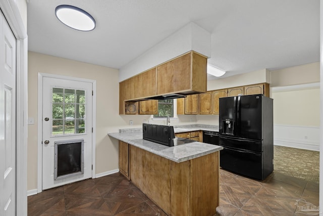 6136 Beasley Rd, Crestview, FL 32536 - kitchen with black appliances, a peninsula, light countertops, brown cabinetry, and healthy amount of natural light