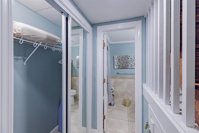 bathroom with tile walls, tile patterned floors, and toilet