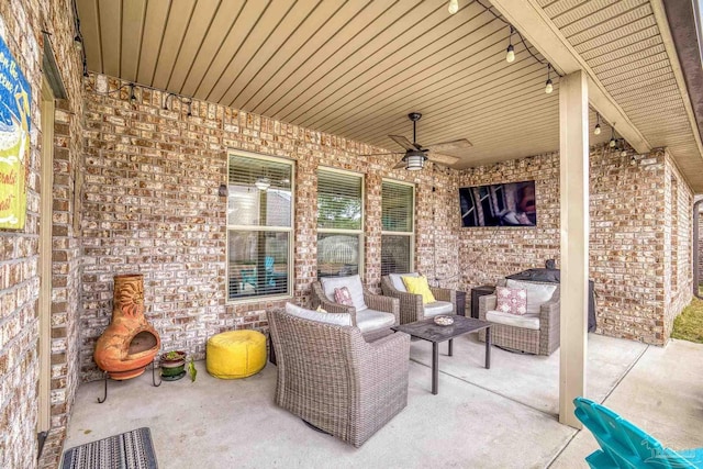 view of patio / terrace with ceiling fan and an outdoor living space with a fireplace