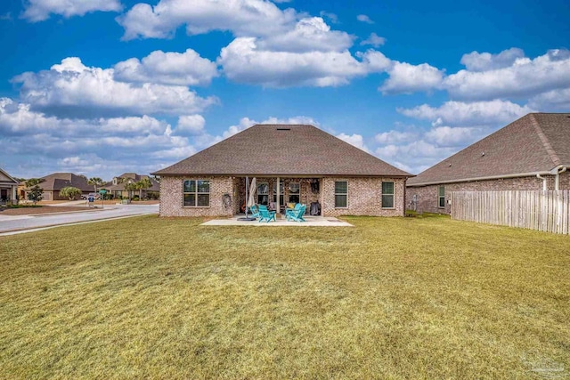 back of property with a patio area and a lawn