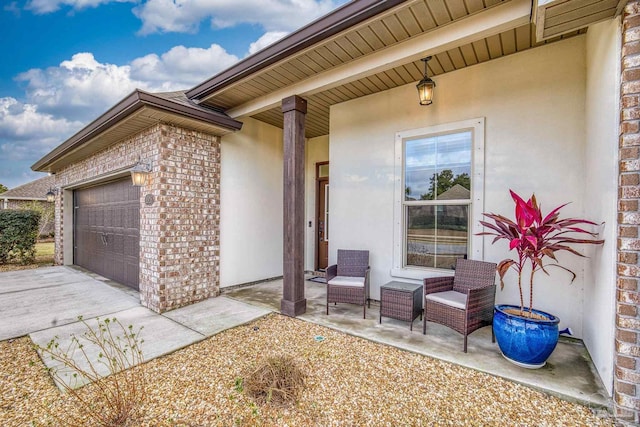 property entrance featuring a garage, concrete driveway, and brick siding