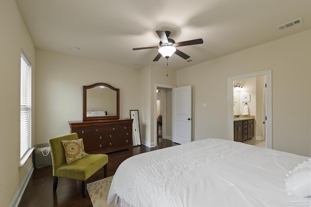 bedroom with ceiling fan, connected bathroom, and dark hardwood / wood-style flooring