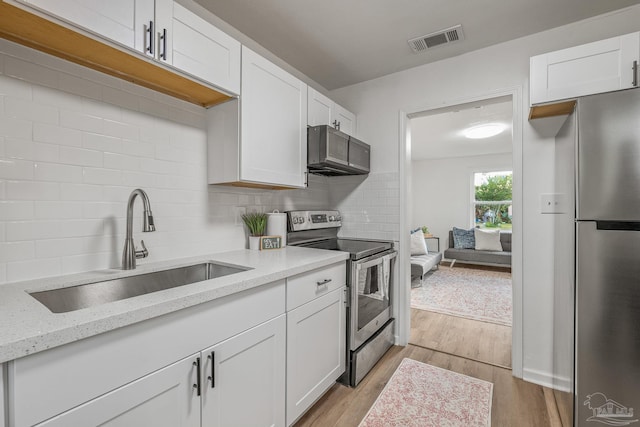 kitchen with visible vents, appliances with stainless steel finishes, decorative backsplash, and a sink