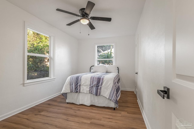 bedroom featuring baseboards, wood finished floors, and ceiling fan