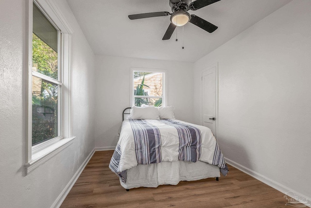 bedroom with baseboards, wood finished floors, and ceiling fan