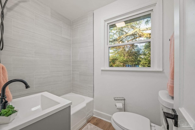 bathroom featuring a sink, toilet, shower / bathing tub combination, baseboards, and wood finished floors