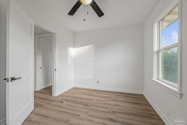 empty room with a ceiling fan, baseboards, and light wood-style floors