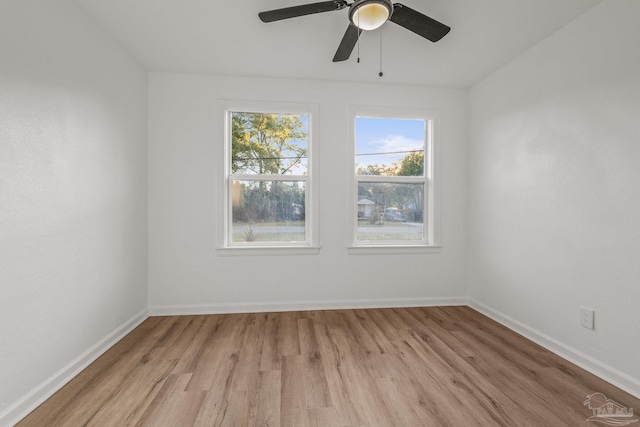 spare room featuring ceiling fan, baseboards, and light wood-type flooring