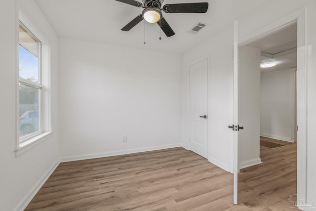 spare room with ceiling fan, baseboards, light wood finished floors, and visible vents