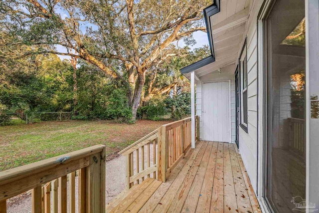 wooden terrace featuring a lawn