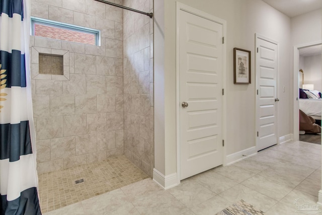 7926 Burnside Loop, Pensacola, FL 32526 - ensuite bathroom with a tile shower, tile patterned flooring, and baseboards