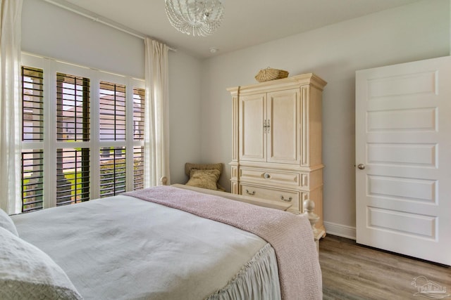 7926 Burnside Loop, Pensacola, FL 32526 - bedroom with a chandelier, wood finished floors, and baseboards