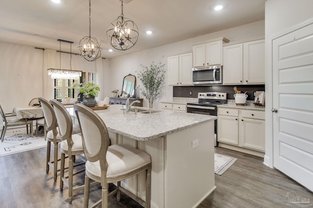 7926 Burnside Loop, Pensacola, FL 32526 - kitchen with stainless steel appliances, a sink, recessed lighting, an island with sink, and a kitchen bar