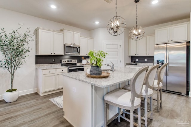 7926 Burnside Loop, Pensacola, FL 32526 - kitchen with appliances with stainless steel finishes, tasteful backsplash, light wood-style flooring, white cabinetry, and recessed lighting