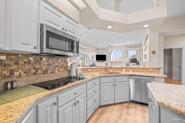 kitchen with open floor plan, stainless steel appliances, tasteful backsplash, and a sink