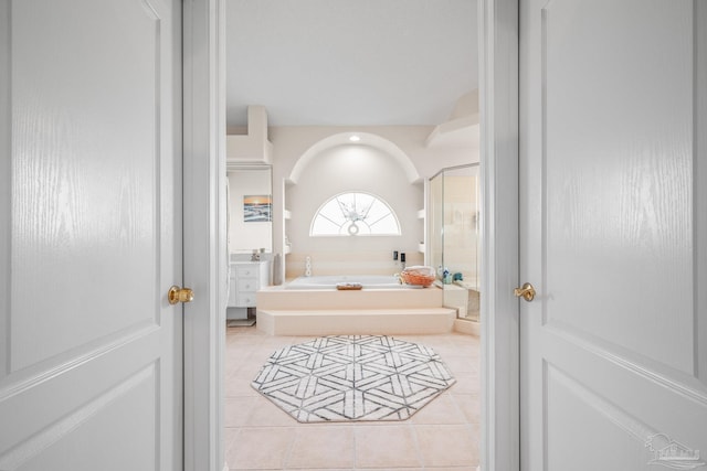 bathroom with tile patterned flooring, a garden tub, and a shower with shower door