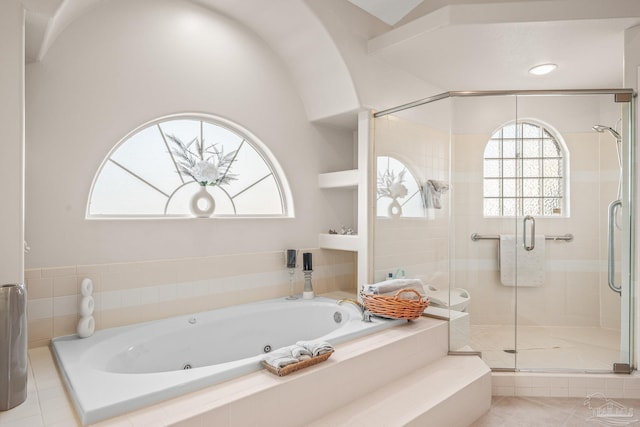 bathroom featuring a tub with jets and a stall shower