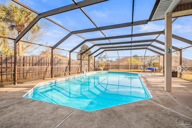 view of pool featuring a patio, glass enclosure, a fenced backyard, and a fenced in pool