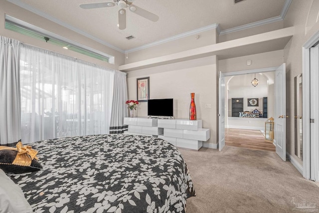 carpeted bedroom with a textured ceiling, ceiling fan, visible vents, baseboards, and ornamental molding