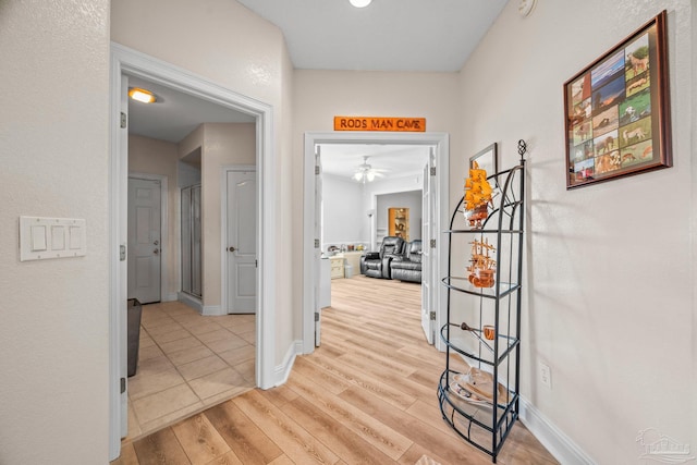 hallway with baseboards and light wood finished floors