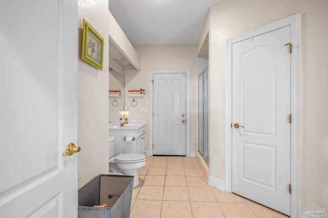 full bathroom with a stall shower, vanity, baseboards, and tile patterned floors