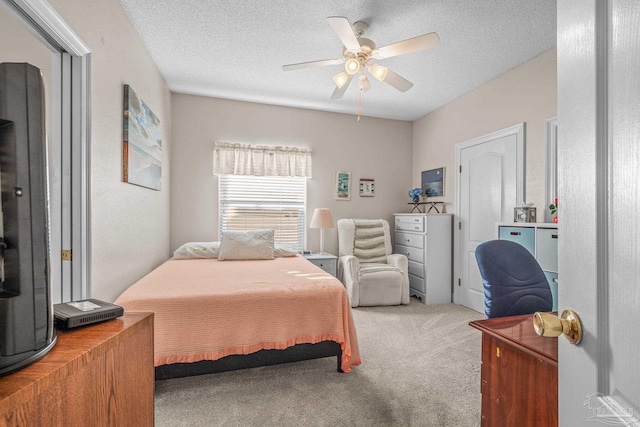 carpeted bedroom featuring ceiling fan and a textured ceiling