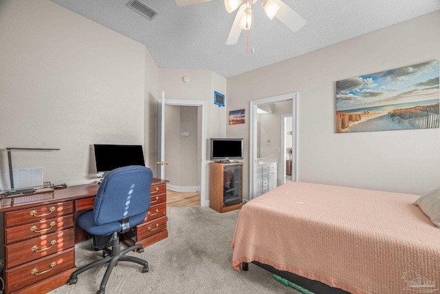 bedroom featuring carpet, visible vents, a ceiling fan, connected bathroom, and a textured ceiling