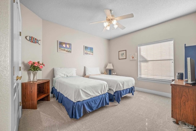 carpeted bedroom featuring a ceiling fan, baseboards, and a textured ceiling