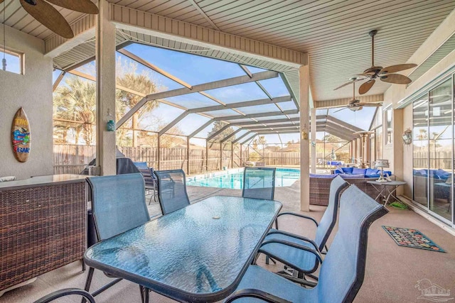 view of patio featuring ceiling fan, glass enclosure, a fenced backyard, an outdoor hangout area, and outdoor dining space