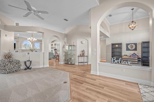 foyer with baseboards, visible vents, wood finished floors, and ceiling fan with notable chandelier