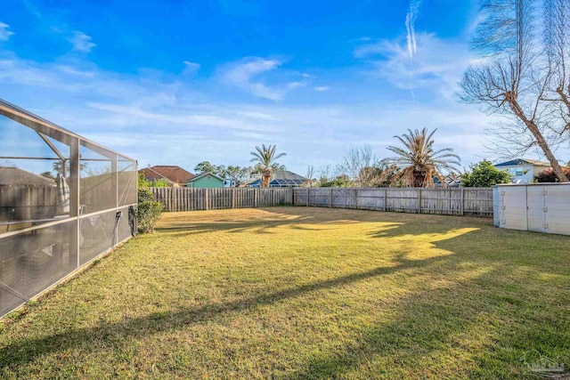 view of yard with a lanai and a fenced backyard